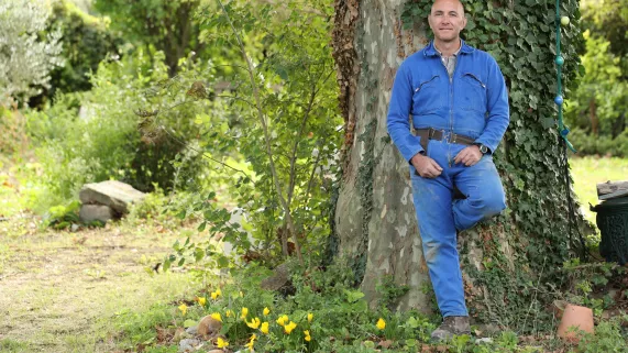Homme adossé à un arbre