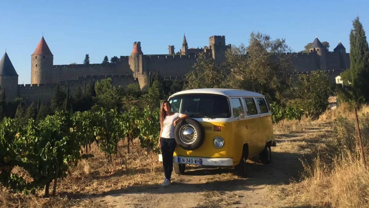 La cité de Carcassonne à l'honneur dans Ô Sud ! Emilie Broussouloux avec un combi avec des vignes autour et la cité de Carcassonne en fond