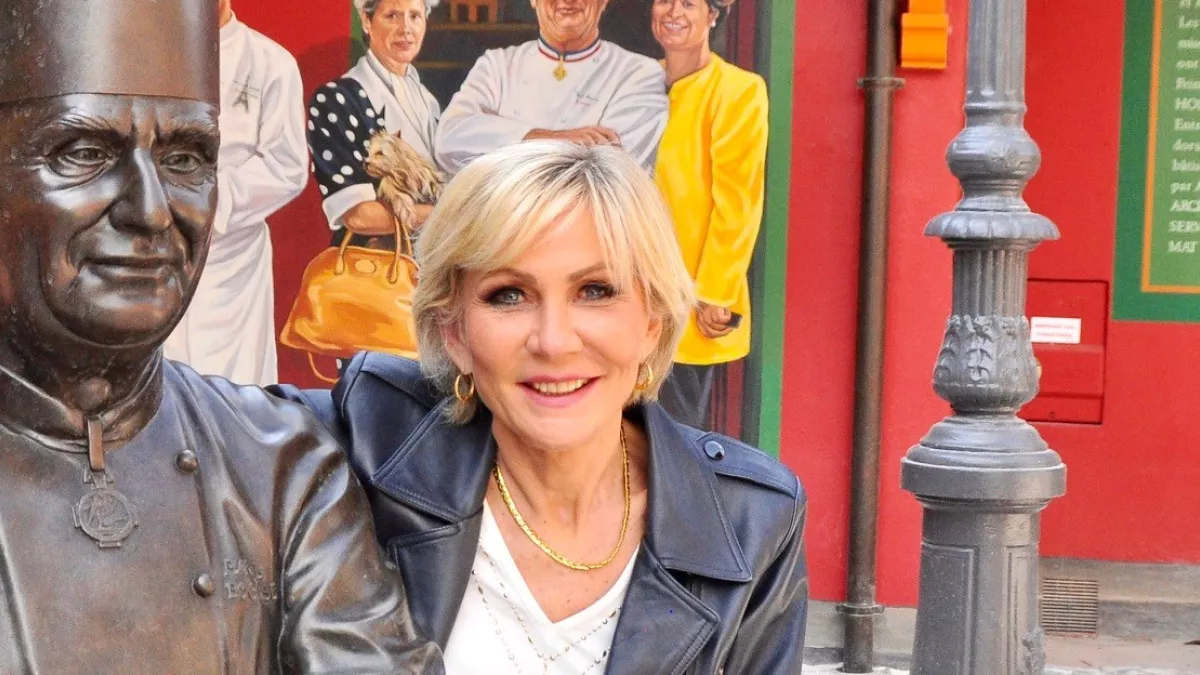 Odile Mattéi devant la statue du chef étoilé Paul Bocuse 