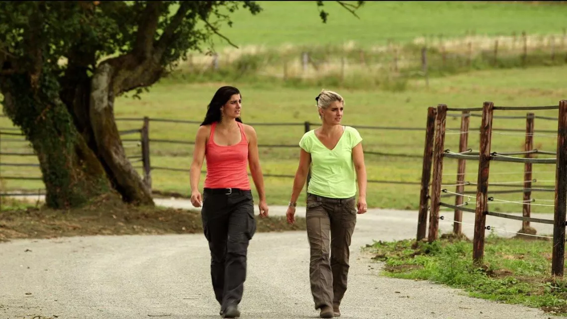 Marie-Laure et sa soeur Claire marchant sur un chemin au milieu des prés