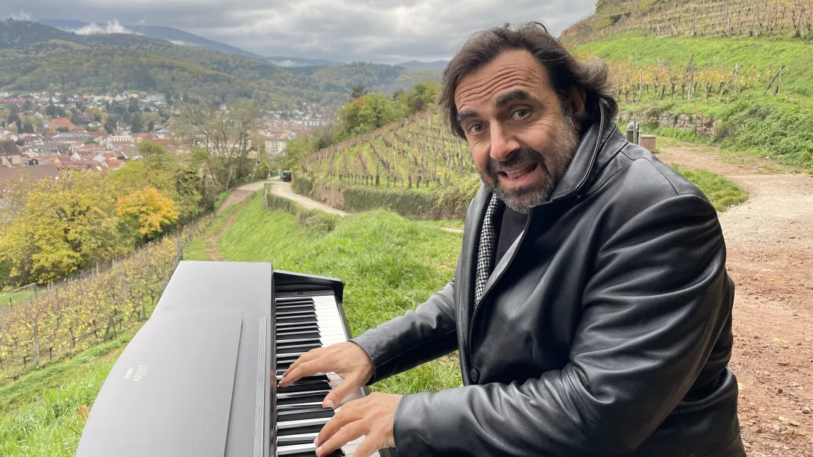 André Manoukian joue du piano au pied des vignes