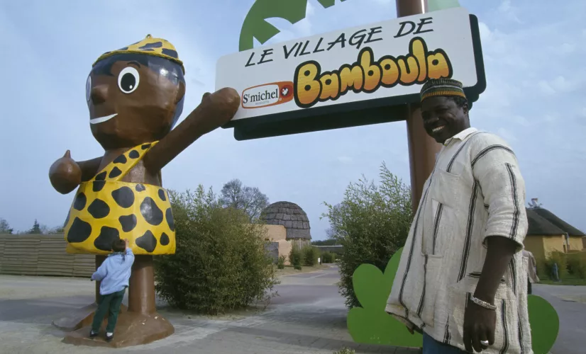 Le village de Bamboula Un artisan ivoirien posant devant le village de Bamboula